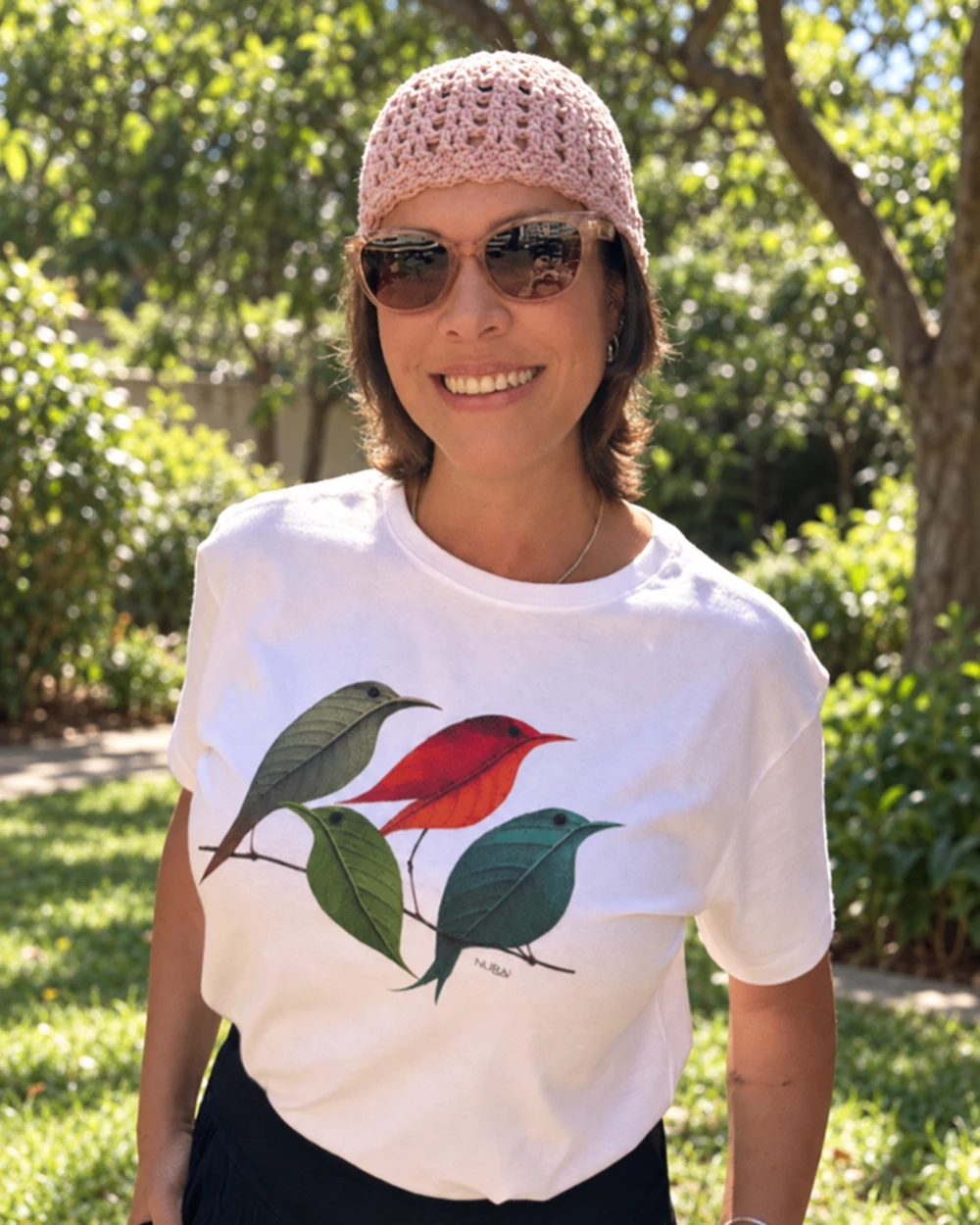 Thais usando a camiseta branca Little Birds, com estampa de pássaros e folhas